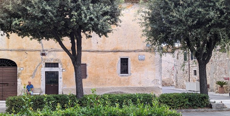 Joachim Braun sitting  outside in front of a house